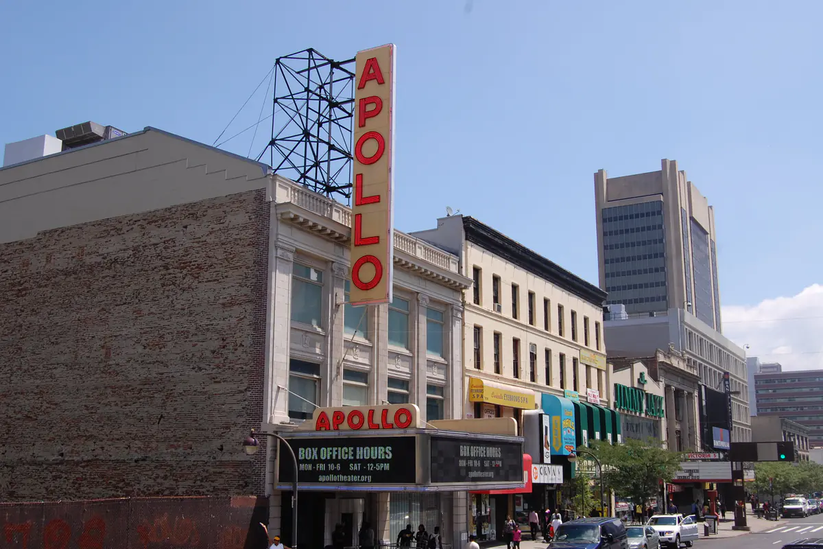 The Apollo Theater on 125th Street, its tall red and white vertical APOLLO sign above the marquee and box office
